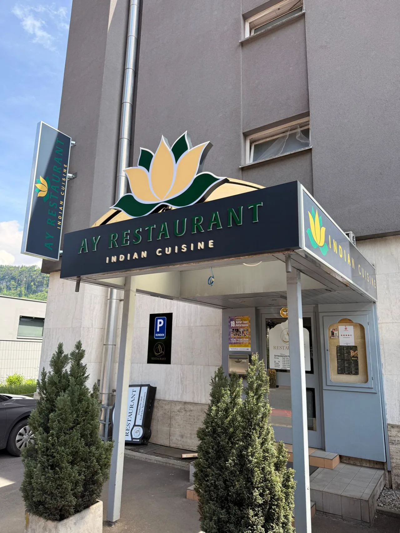Neuer dunkelgrüner Auftritt des AY Restaurant mit 3D-Lotusblüte und Schriftzug Indian Cuisine