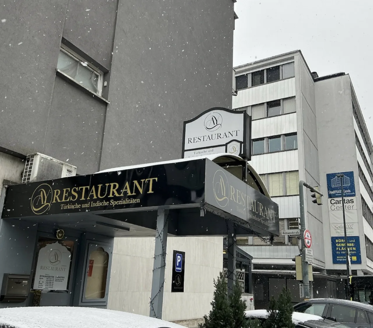 Alter schwarz-goldener Vordachschriftzug des AY Restaurant bei Schneefall