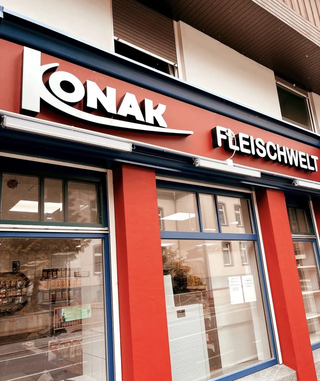 Rote Fassade der Konak Fleischwelt mit weißen 3D-Buchstaben über der Schaufensterfront