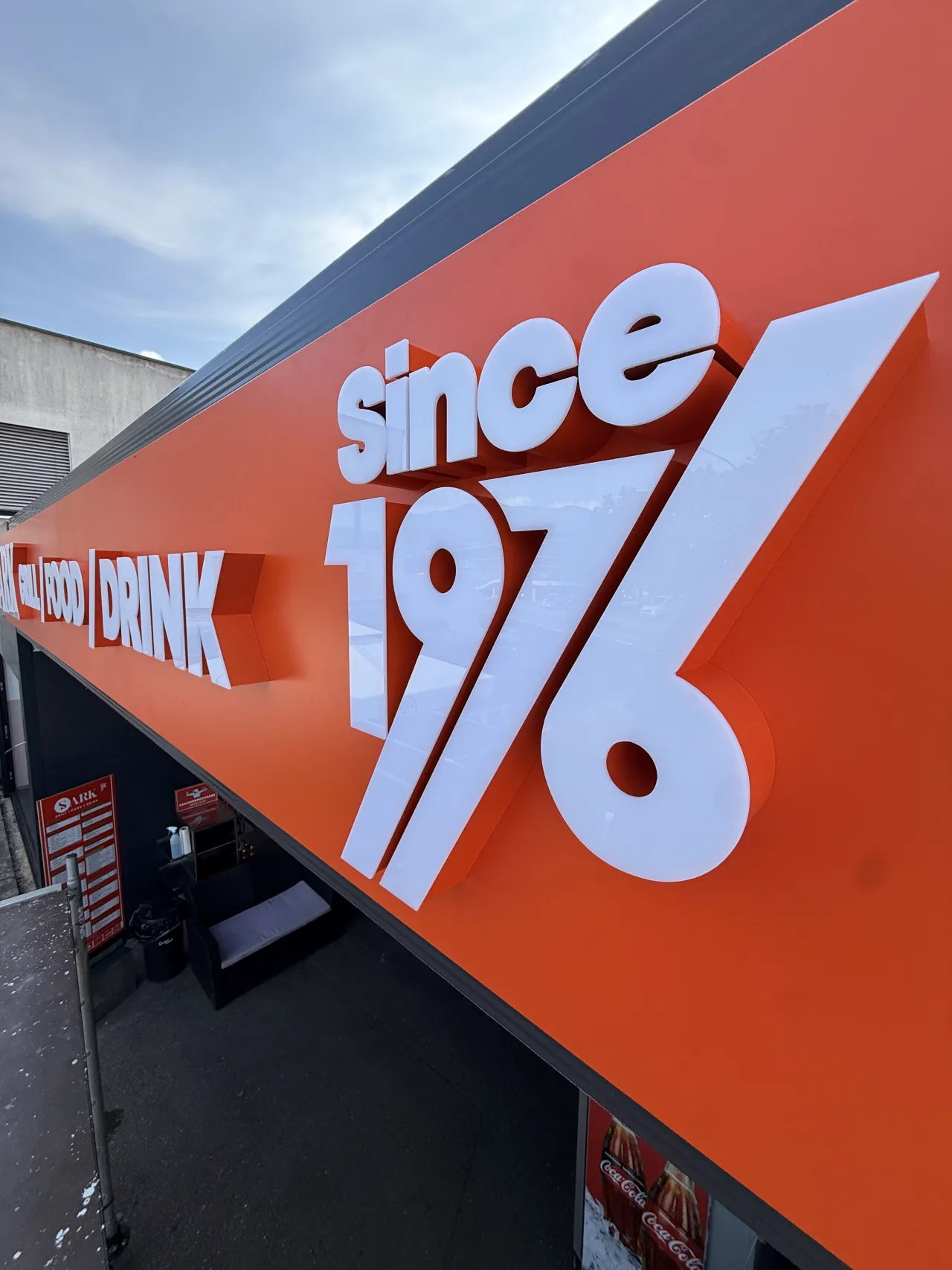 Nahaufnahme der weißen 3D-Buchstaben since 1976 auf orangefarbenem Untergrund